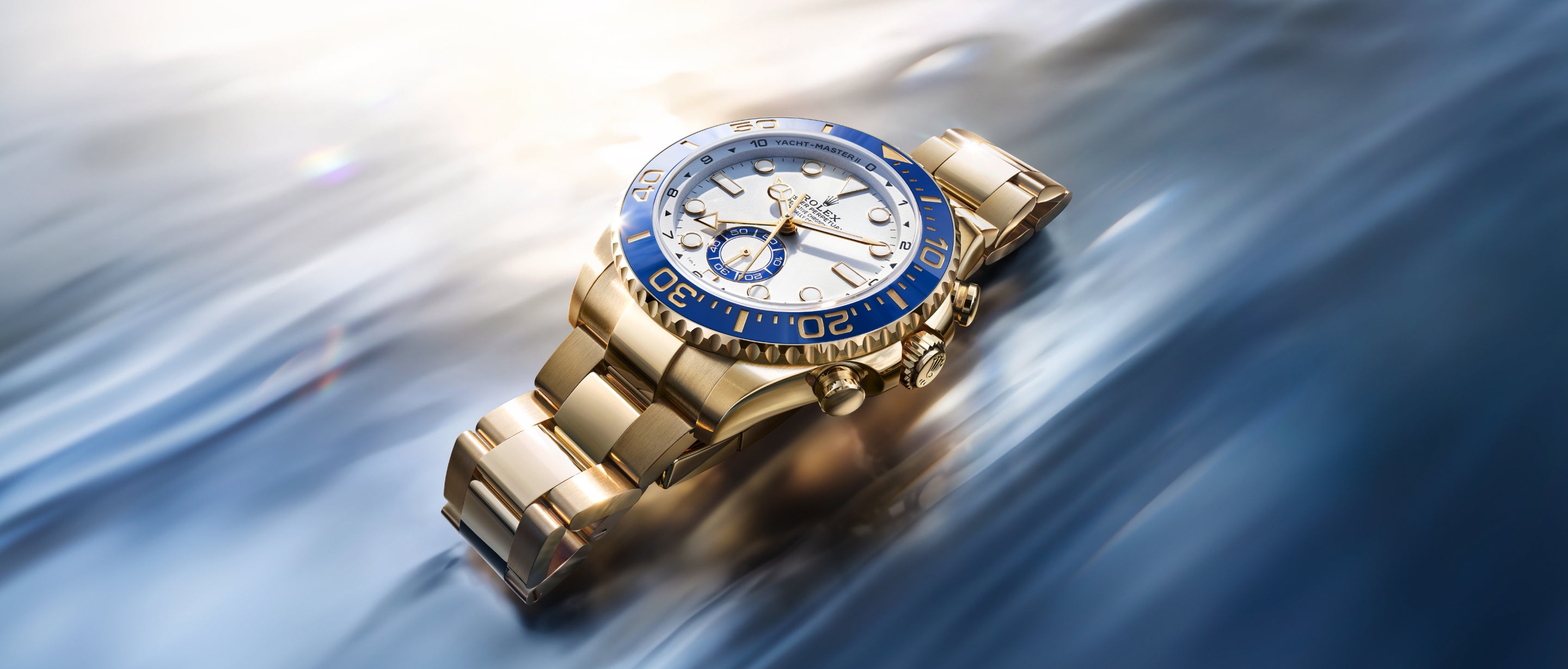 Rolex Yacht-Master II in 18 kt yellow gold with blue Cerachrom bezel in a nautical setting