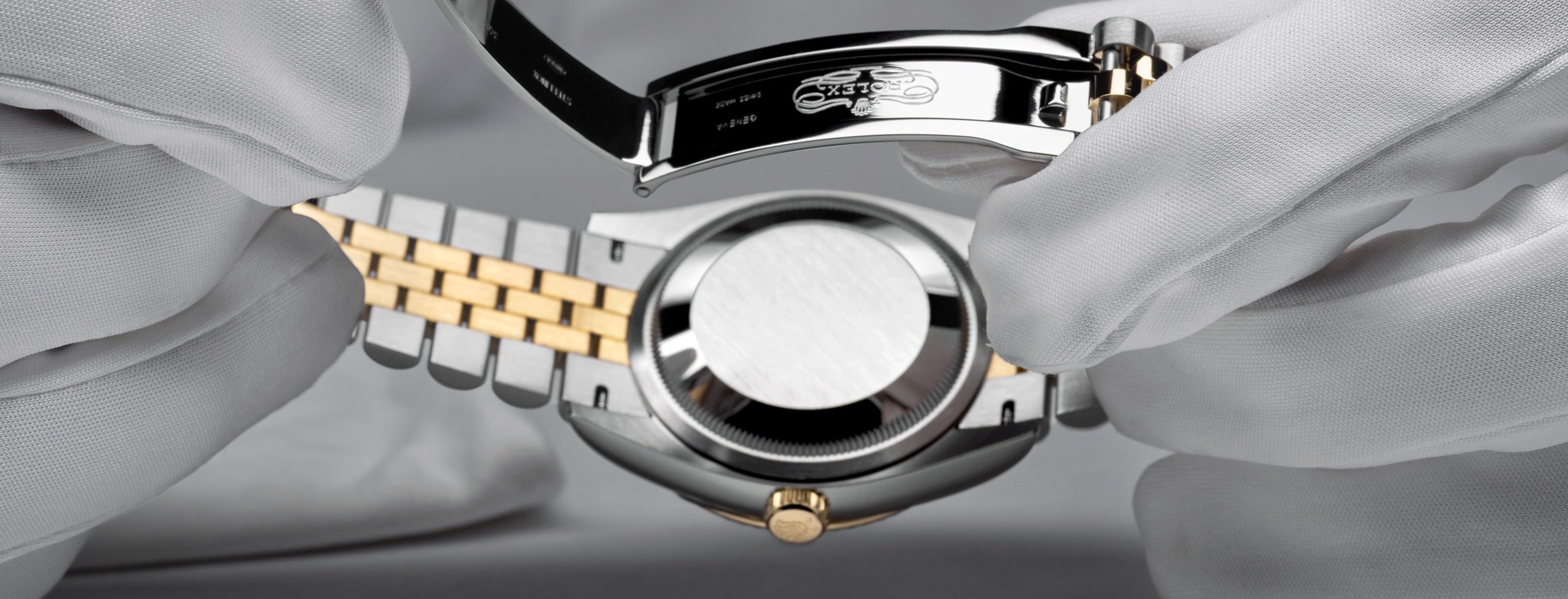 Rolex watch receiving final inspection by someone wearing cloth gloves to protect the appearance of the Rolex timepiece